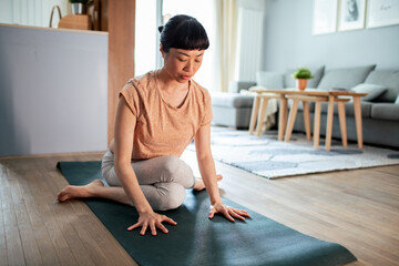 Young Japanese woman doing yoga at home