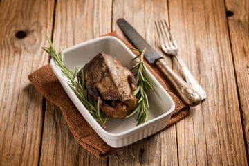 roasted pigeon with herbs over wood background