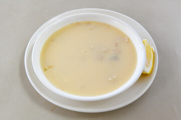 Homemade turkish soup Tavuk Suyu corbasi in a white ceramic soup plate.Turkish noodle chicken broth soup on a plate. Turkish meal (sehriyeli tavuk suyu corbasi)
