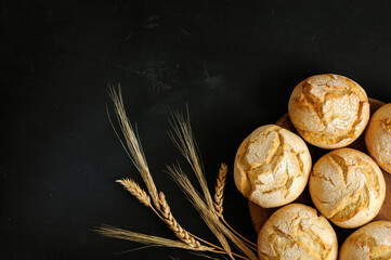 Appetizing fresh round buns on a black shabby background. copy space for text. Top view, selective focus in natural light.