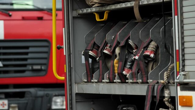 Rolled fire hoses, arranged in rows and fire extinguishing equipment, in the glove compartment of the fire truck. Fire truck, open side of van