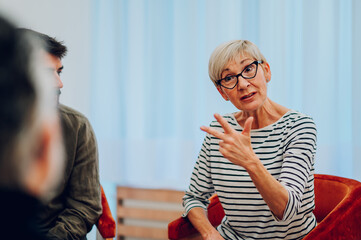 Senior woman talking about her mental health on a group therapy session