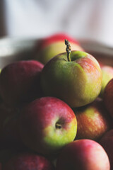 Woman holding apples in a metal bowl