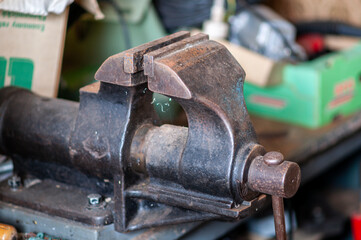 Old iron vice in the workshop on the workbench.
