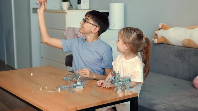 Children play with a metal constructor at the table at home.Mothers Day,Family Games,Home Education,Educational Games