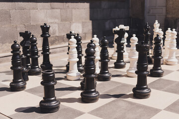 Giant chess on board located on ground outdoor - intellectual game