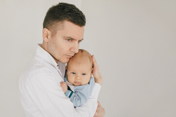 Father and baby boy, wearing casual clothes on white background.