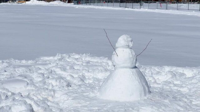 Lone Snowman in Park Field: Winter Fun at Playground