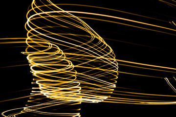 Abstract lights of golden colors forming patterns of curved lines. Festive decoration.