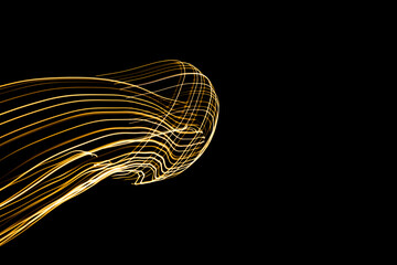 Abstract lights of golden colors forming patterns of curved lines. Festive decoration.