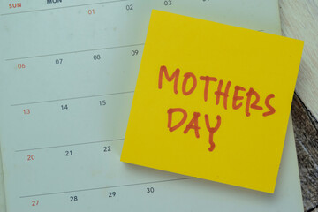 Concept of Mothers Day write on sticky notes with calendar isolated on Wooden Table.