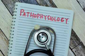 Concept of Pathophysiology write on book with stethoscope isolated on Wooden Table.