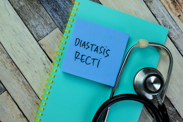 Concept of Diastasis Recti write on sticky notes with stethoscope isolated on Wooden Table.