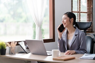 Creative Asian young woman working on laptop in her office.