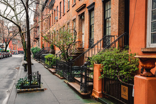 Historic buildings with fire escape ladders, parking cars in NYC.