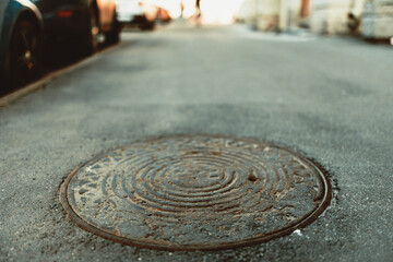 Sunny day. Selective Focus. Close up view of a manhole cover