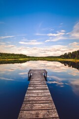 Beautiful summer afternoon landscape by the lake. Charming wooden pier over a small lake in Michala Gora, Poland.