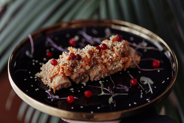 pancakes with meat in the form of a roll on a black plate against the background of ferns