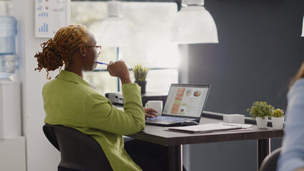Executive manager working on marketing vision at desk, brainstorming new development ideas. Female worker checking online analytics in office, thinking about business solution.