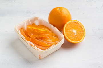 Wicker birch basket with fresh juicy candied oranges with fresh juicy orange on a light gray...