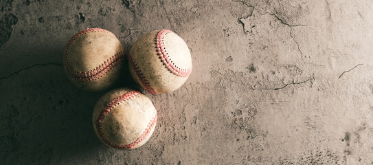 Old used baseballs with copy space on grunge concrete texture background.