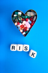 The effect of excess drugs on the heart. The concept of moderate drug use. The inscription RISK on...