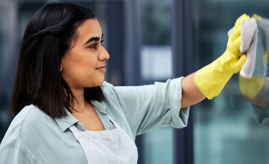 Cleaner windows for a better view. Closeup shot of a woman wearing gloves and using a cloth while...