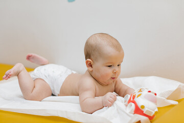 A newborn baby is played with a toy at the doctor's office. Copy space.