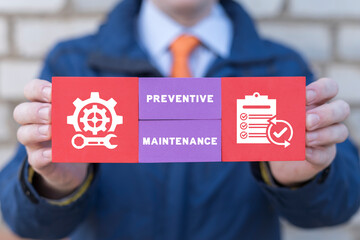 Businessman holding colorful blocks with icons and inscription: PREVENTIVE MAINTENANCE. Preventive...