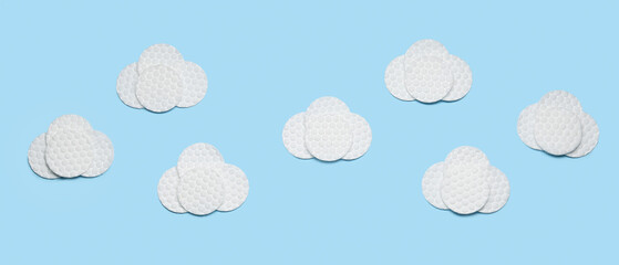 Clouds made of cotton pads on light blue background