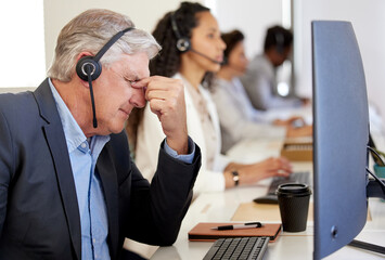 The solution is nowhere in sight. a mature call centre agent looking stressed out while working in...