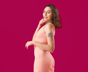 Naklejka na ściany i meble Attractive young woman in dress on pink background