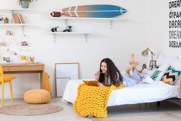 Teenage girl with notebook in bedroom