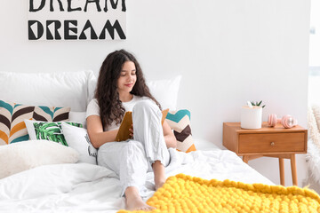 Teenage girl with notebook in bedroom
