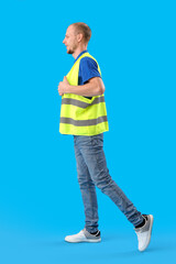 Male worker in vest on blue background