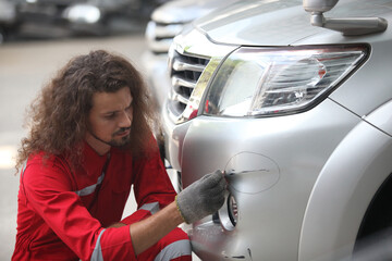 auto mechanic worker painting, automobile repairman painter in protective workwear and respirator painting car body in paint chamber