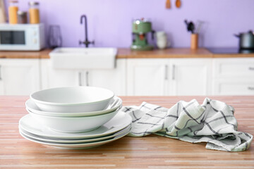 Set of dishes and napkin on wooden table in kitchen