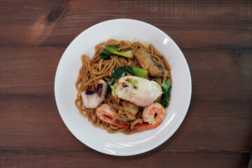 Mee Pad Hokkien or Stir-fried Hokkien Mee or Hokkien Noodles. Phuket Original Hokkien Noodles consists of thick yellow (egg) noodles fried with seafood, pork and vegetables. Selective focus