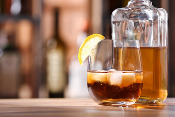 Glass and bottle of cold rum on table in bar