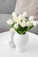 Vase with beautiful tulip flowers and ceramic hand on table, closeup