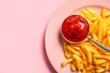 Plate of tasty french fries and ketchup on pink background