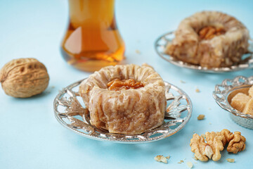 Plate with tasty baklava on blue background