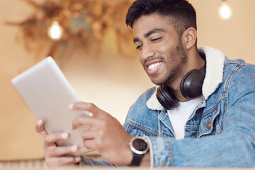 Taking my work with me on the go. a young man using a digital tablet in a coffee shop.
