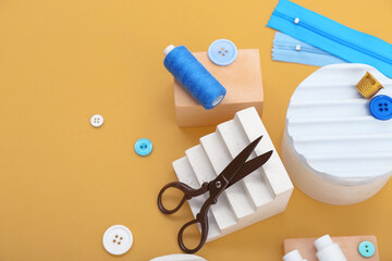 Podiums with tailor's supplies on beige background