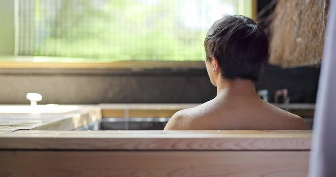 Asian man soak into onsen at hotel resort