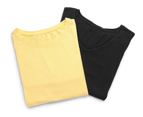 Folded yellow and black t-shirts on white background