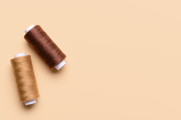 Two thread spools on color background