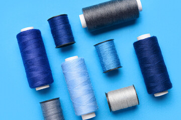 Composition with different thread spools on color background, closeup