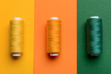 Colorful sewing threads on color background