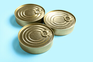 Tin cans with fish on blue background